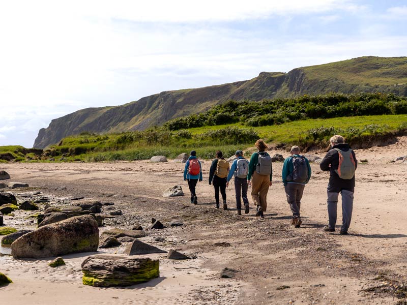 Hikers walking along a beach