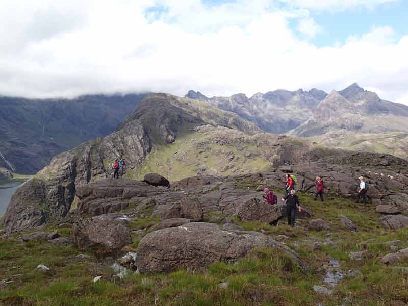 people walking on a rocky mountain plateau.