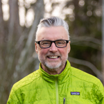 Guide Tom smiles into the camera while out in the woods