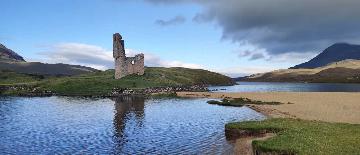ruins of a castle on a loch in the highlands of scotland