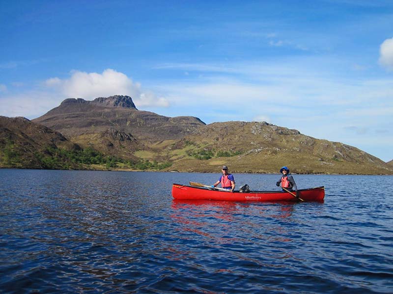Responsible tourism - two people canoeing on a loch in assynt. 